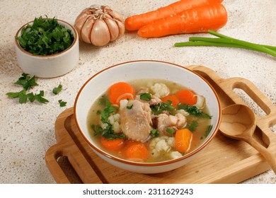 Homemade chicken soup with vegetables in a white bowl.Healthy warm comfortable food. - Shutterstock ID 2311629243