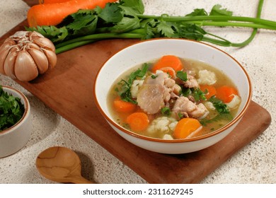 Homemade chicken soup with vegetables in a white bowl.Healthy warm comfortable food. - Shutterstock ID 2311629245