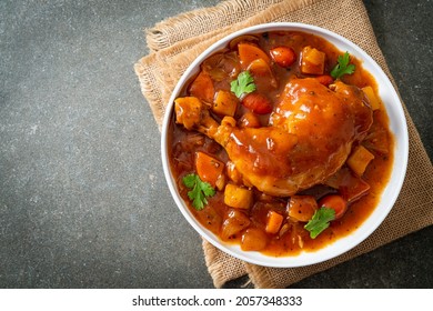 homemade chicken stew with tomatoes, onions, carrot and potatoes on plate - Shutterstock ID 2057348333