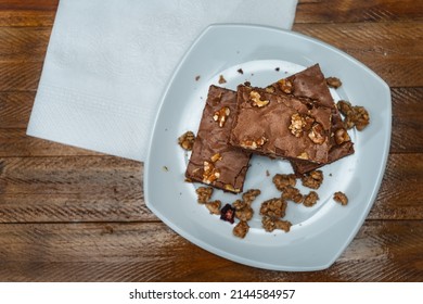 Homemade Chocolate Brownie Squares With Pecan Pieces Served On A White Plate. Natural, Healthy Food Concept. Top View.