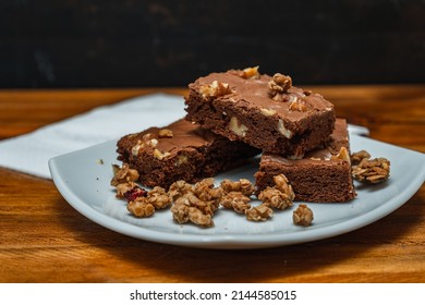 Homemade Chocolate Brownie Squares With Pecan Pieces Served On A White Plate. Natural, Healthy Food Concept. High View.