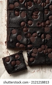 Homemade Chocolate Brownies With Dark Chocolate On A Baking Paper, Isolated On A White. Overhead View.