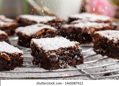 Homemade Chocolate Brownies With Icing Sugar On A Cake Rack.