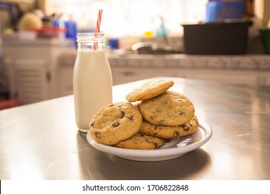 Homemade chocolate chip cookies with a glass of milk on the kitchen table - children's snack - Powered by Shutterstock