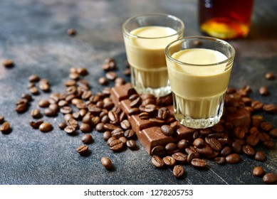 Homemade chocolate coffee cream liquor in a shotglass on a dark slate,stone or metal background.