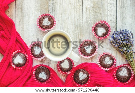 Homemade chocolate cupcakes with hearts and a Cup of coffee for Breakfast. Selective focus. Wooden background.