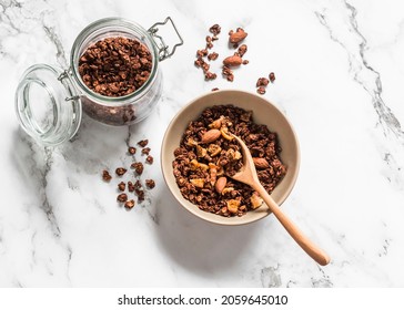 Homemade chocolate granola with oatmeal, dried figs and almonds on a light background, top view    