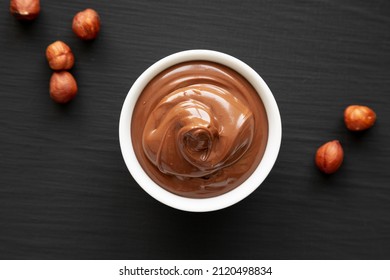 Homemade Chocolate Hazelnut Spread In A Bowl On A Black Surface, Top View. Flat Lay, Overhead, From Above. 