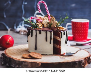 Homemade Christmas Cake Decorated With Gingerbread Men, Waffles And Candy Canes On A Rustic Wood Stand