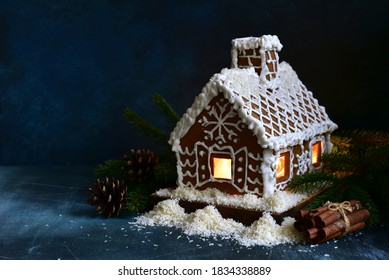 Homemade christmas gingerbread house on a dark blue slate, stone or concrete background.