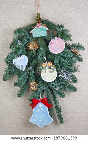 Homemade Christmas tree branch decoration of toys   made of wood,  plaster and  bow