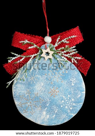 Homemade Christmas tree decoration ball  made of wood, plaster and bow . Isolated on black