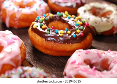 homemade colorful donuts with chocolate and icing glaze on wooden background - Powered by Shutterstock