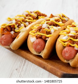 Homemade Coney Island Chili Dog On A Rustic Wooden Board On A White Wooden Background, Side View. Close-up.