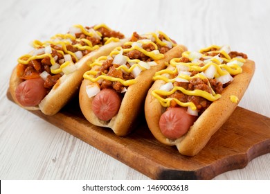 Homemade Coney Island Hot Dog On A Rustic Wooden Board On A White Wooden Surface, Side View. Close-up.