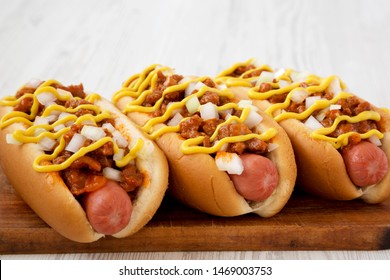 Homemade Coney Island Hot Dog On A Rustic Wooden Board On A White Wooden Background, Side View. Close-up.