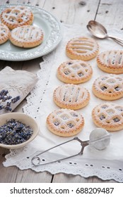 Homemade cookies mini pies with jam and lavender on a white napkin and gray wooden background