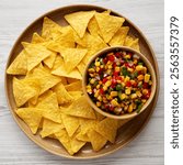 Homemade Corn Salsa with Tortilla Chips on a Plate, top view. Flat lay, overhead, from above. 