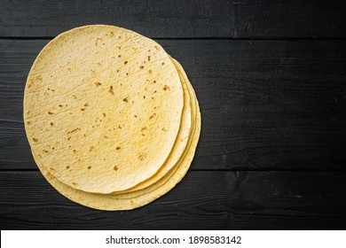 Homemade corn tortilla, on black wooden table background, top view flat lay with copy space for text