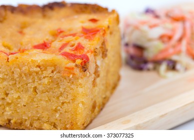 Homemade Cornbread Cut Into Squares And Salad On Wood Plate With