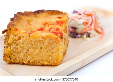 Homemade Cornbread Cut Into Squares And Salad On Wood Plate With