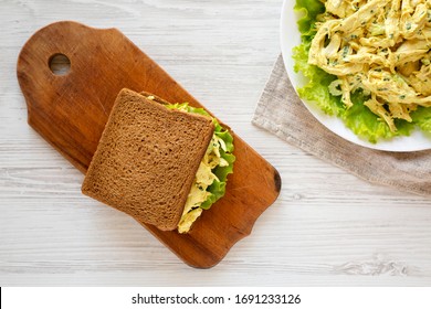 Homemade Coronation Chicken Sandwich On A Rustic Wooden Board On A White Wooden Table, Top View. Overhead, From Above, Overhead. 