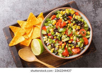 Homemade Cowboy salad or Texas caviar bean dip lime dressing, served with tortilla chips closeup in the bowl on the wooden board. Horizontal top view from above
 - Powered by Shutterstock