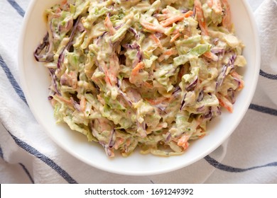 Homemade Creamy Broccoli Slaw In A White Bowl On Cloth, View From Above. Flat Lay, Top View, Overhead. Close-up.