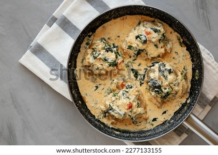 Homemade Creamy Tuscan Chicken with Spinach in a Pan, top view. From above, overhead, flat lay. Copy space.