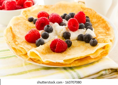 Homemade crepes with fresh raspberries and blueberries. - Powered by Shutterstock