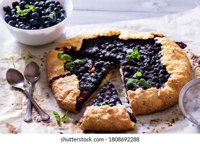 Homemade crispy blueberry pie or galette and mint.  Summer, bright, delicious pies framed with flowers and herbs with berry