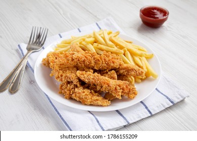 Homemade Crispy Chicken Tenders And French Fries On A White Plate, Side View.