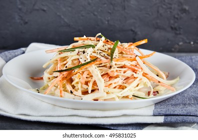 Homemade, Crunchy Salad Coleslaw Made The Traditional Way And Decorated With Herbs And Ground Pepper. Shredded Carrot, Cabbage And Apple, Dressed With Mayonnaise On White Plate. Black Background.