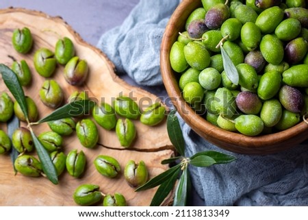 Homemade crushing olive making. Fresh green olives are breaking one by one. Crushing olives with stone. Preparing pickled olives in Turkish style. (Turkish name; kirma zeytin) Foto stock © 
