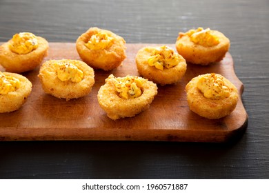 Homemade Deep-fried Deviled Eggs With Paprika On A Rustic Wooden Board, Side View.