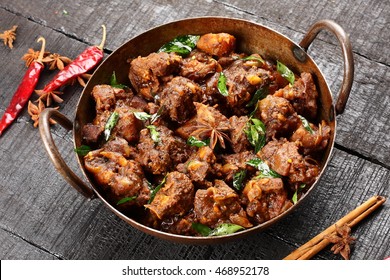 Homemade delecious mutton roast with Indian spices,,Rustic wooden background,Selective focus photograph