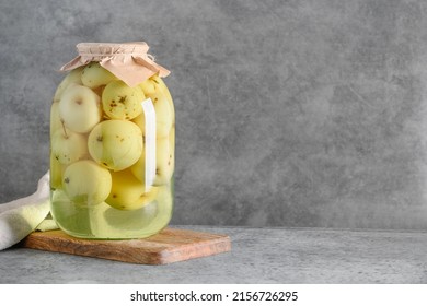 Homemade delicious canned apple compote in large glass jars on gray table. Space for text.