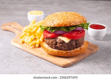 Homemade delicious hamburger with beef, onion, tomato, lettuce and cheese. Fresh burger close up on wooden rustic table with potato fries. Cheeseburger. Burger. - Powered by Shutterstock