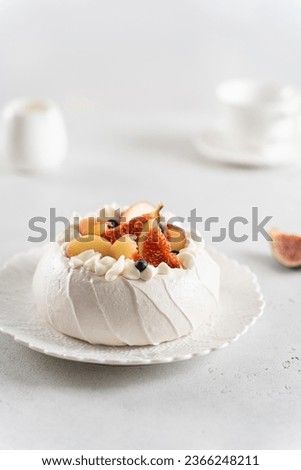 Homemade delicious meringue Pavlova cake with fresh blueberry, figs, peach and mascarpone on white background. Vertical. Copy space. Confectionery, recipe, menu. Meringue summer dessert