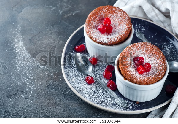 Homemade delicious souffle with dried cherries\
on the concrete a dark\
background