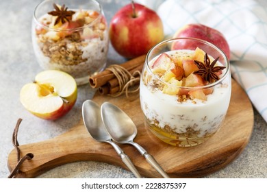 Homemade dessert with yogurt, granola, caramel apples and cinnamon on a stone table. Healthy breakfast granola, healthy lifestyle.  - Powered by Shutterstock