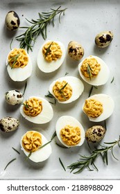 Homemade Deviled Eggs With Quail Eggs Around As A Decoration On A Gray Tray