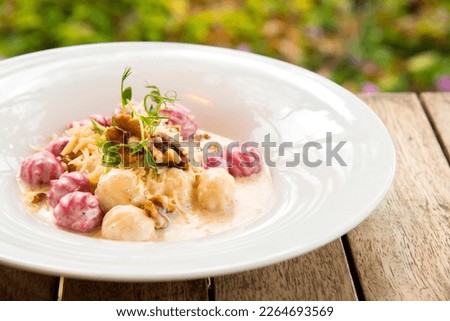 Homemade dish white and pink (beetroot) gnocchi in Cheesy cream sauce
