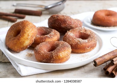Homemade donuts with sugar and cinnamon on a wooden background. Rustic style.