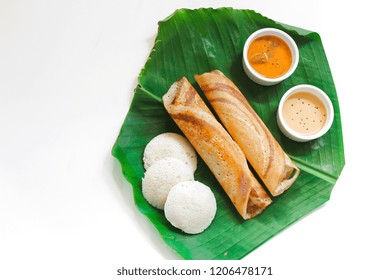 Homemade Dosa (Ghee Roast) And Idli With Chutney And Sambar On Banana Leaf Isolated On White, Top View/ South Indian Breakfast Thali