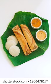 Homemade Dosa (Ghee Roast) And Idli With Chutney And Sambar On Banana Leaf Isolated On White, Top View/ South Indian Breakfast Thali