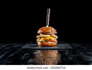 Homemade double cheese burger with onion ring. Laid out on black slate. Black background. - Powered by Shutterstock