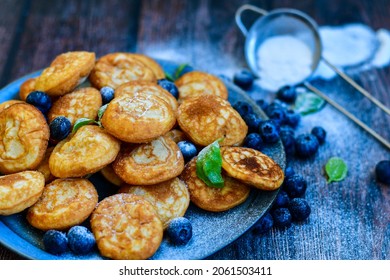 Homemade Dutch Poffertjes  Mini Pancakes with butter , Powdered Sugar  and blueberries