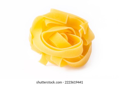 Homemade egg pasta tagliatelle. Raw nest noodles, uncooked ribbon fettuccine, dry long rolled macaroni isolated on white background top view - Powered by Shutterstock