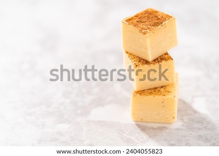 Homemade eggnog fudge pieces on a kitchen counter.